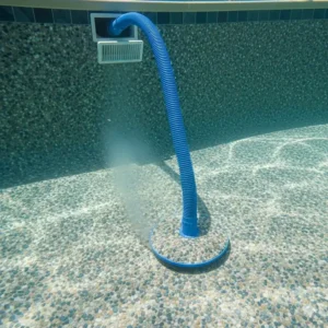 A durable suction-side pool vacuum connected to a pool's skimmer, demonstrating how it adheres to and cleans the textured Pebble Tec finish.