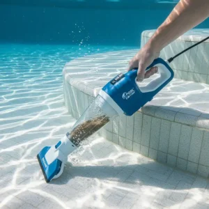 Detailed view of the Pool Blaster Catfish handheld pool vacuum being used to clean pool steps or a small spa.
