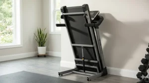 A folding treadmill tucked away in an upright position against a wall to demonstrate space-saving benefits.