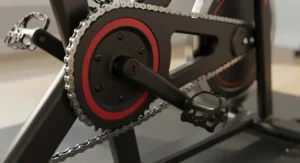 Close-up view of the chain drive mechanism on an indoor cycling bike, showing the durable metal chain and sprocket.