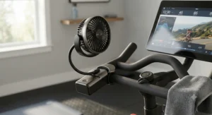 Adjustable battery-operated fan attached to Peloton handlebars for cooling during intense rides